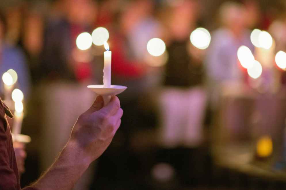 person holding white taper candle